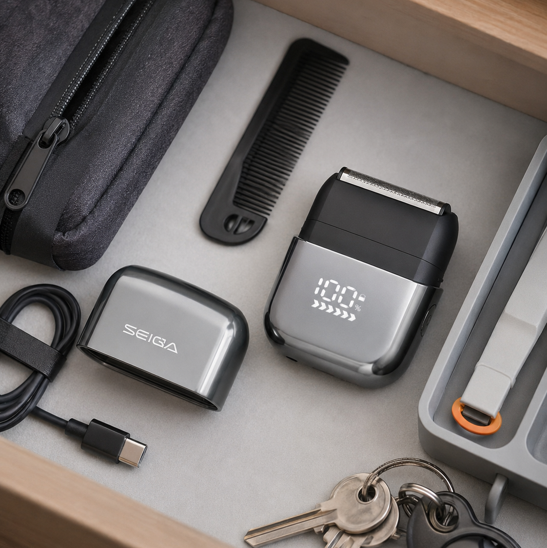 A Seiga personal care organizer set displayed inside a wooden drawer, including a black and silver electric trimmer with a digital LED display, a matching charging case, a USB-C cable, a black comb, and a gray zippered pouch.